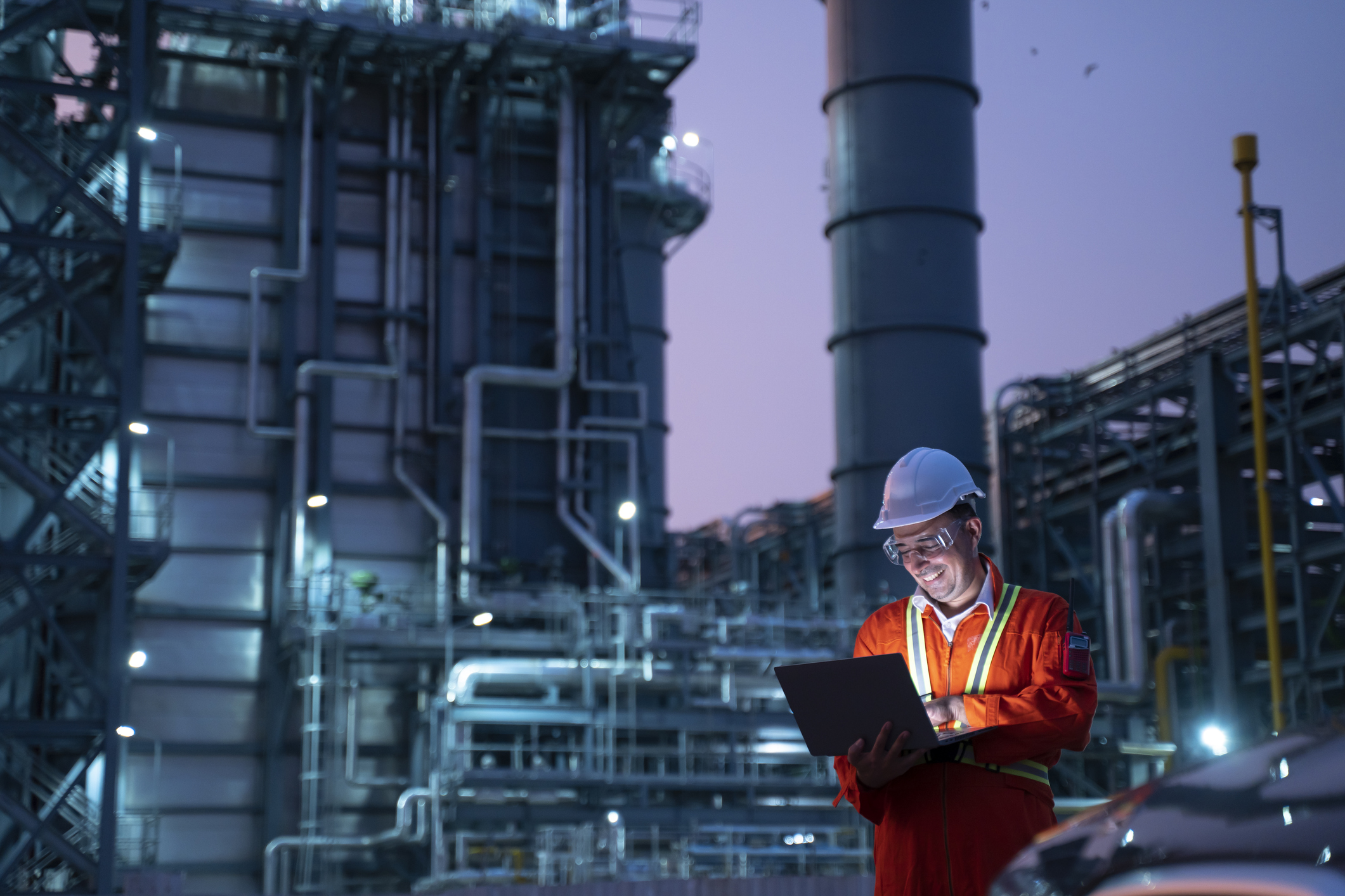 Petrochemical engineers work slowly and heavily with smart tablets in the oil and gas industry at night.